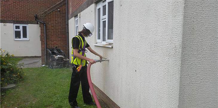 Wall being injected with insulation material